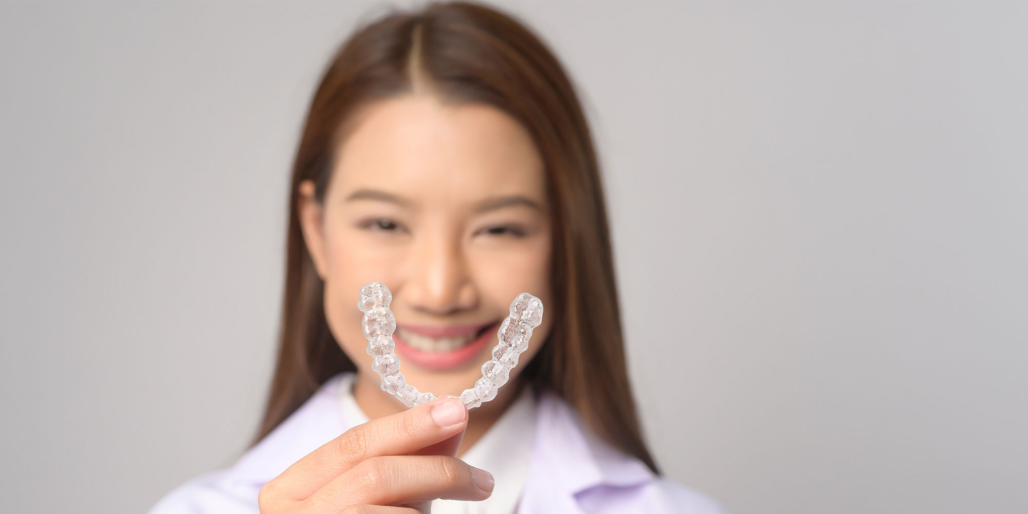 Paitent holding up invisalign