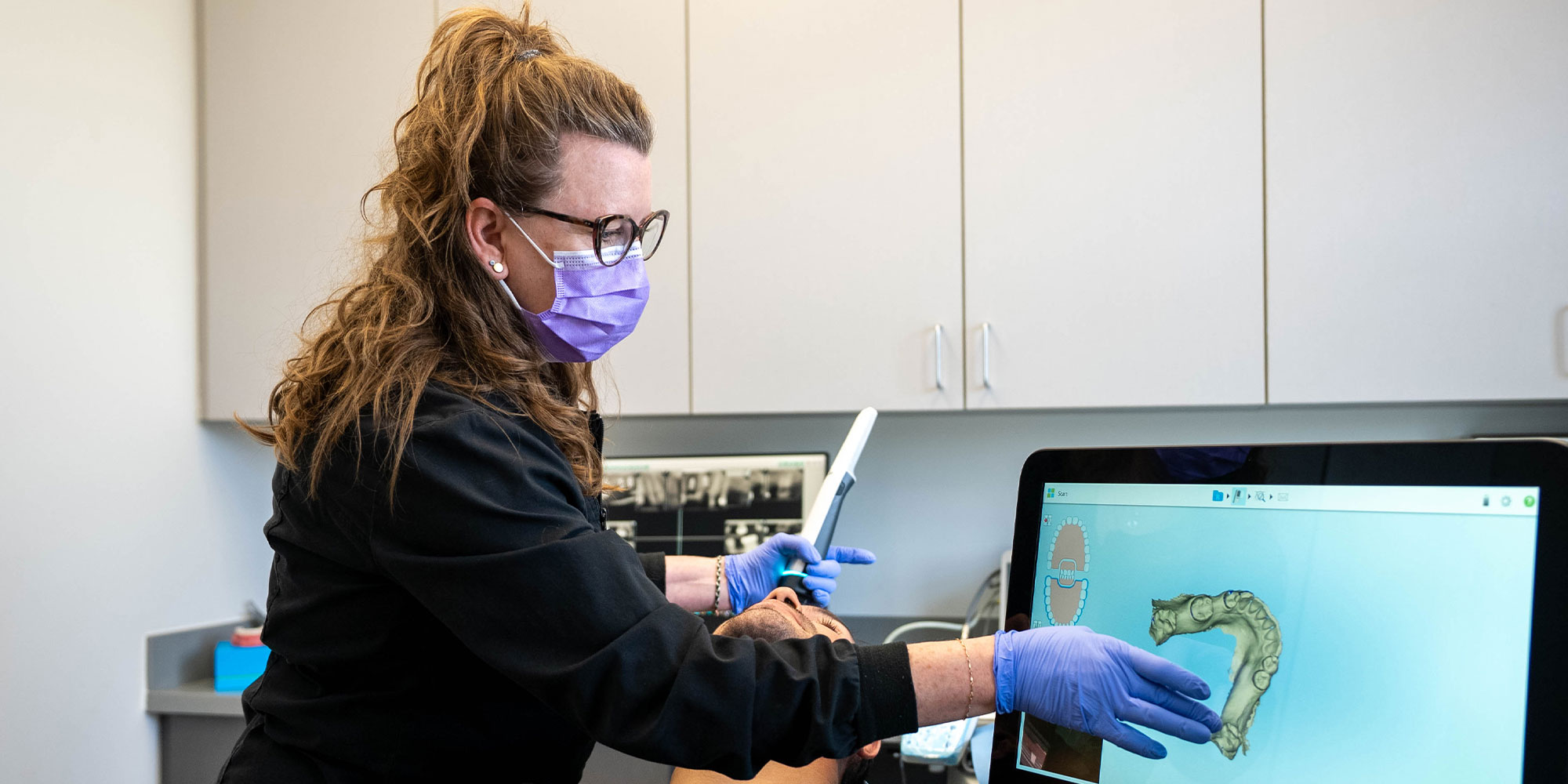 team member looking at a 3d scan of patients teeth