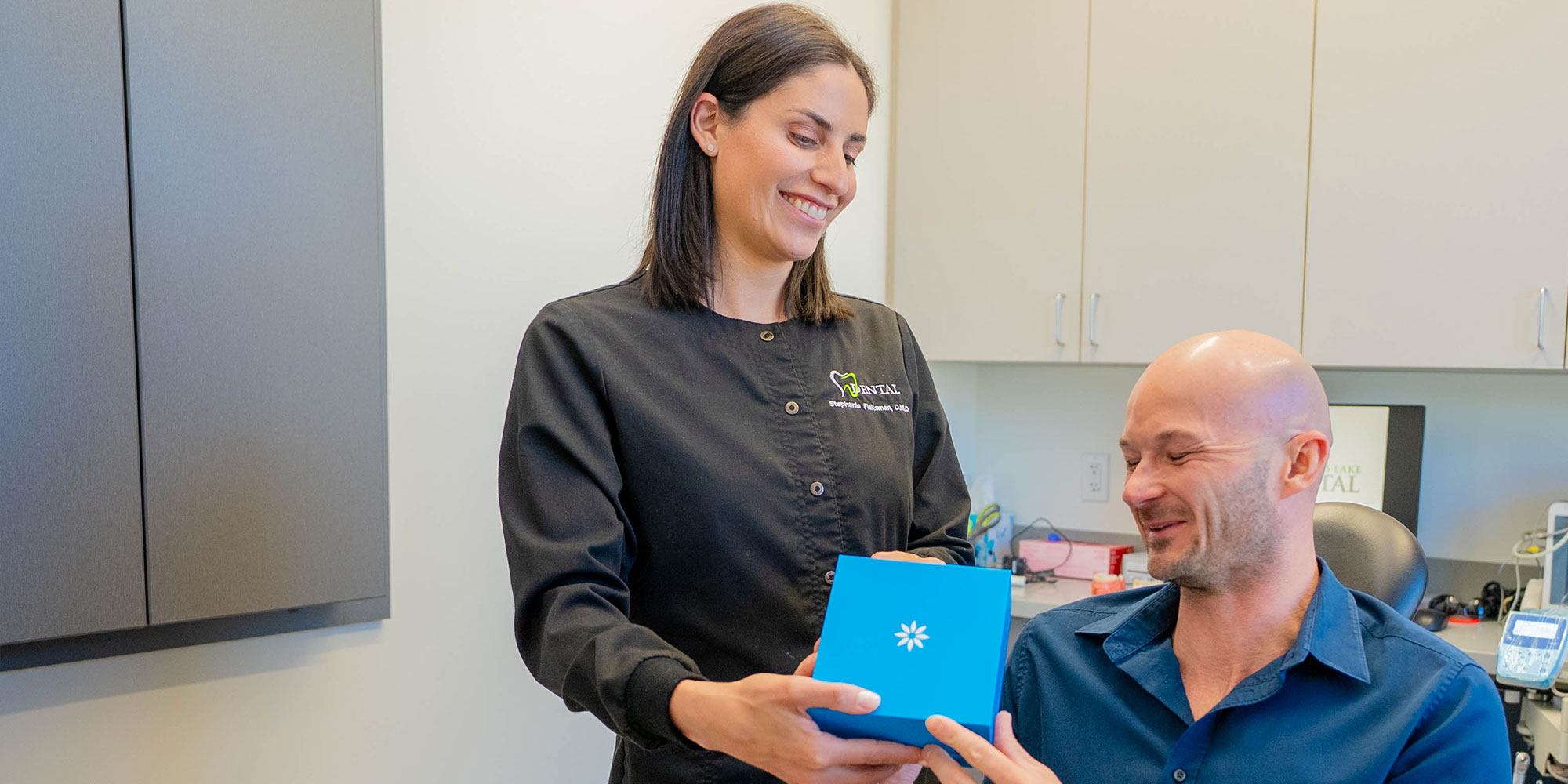 team member handing Paitent box of invisalign