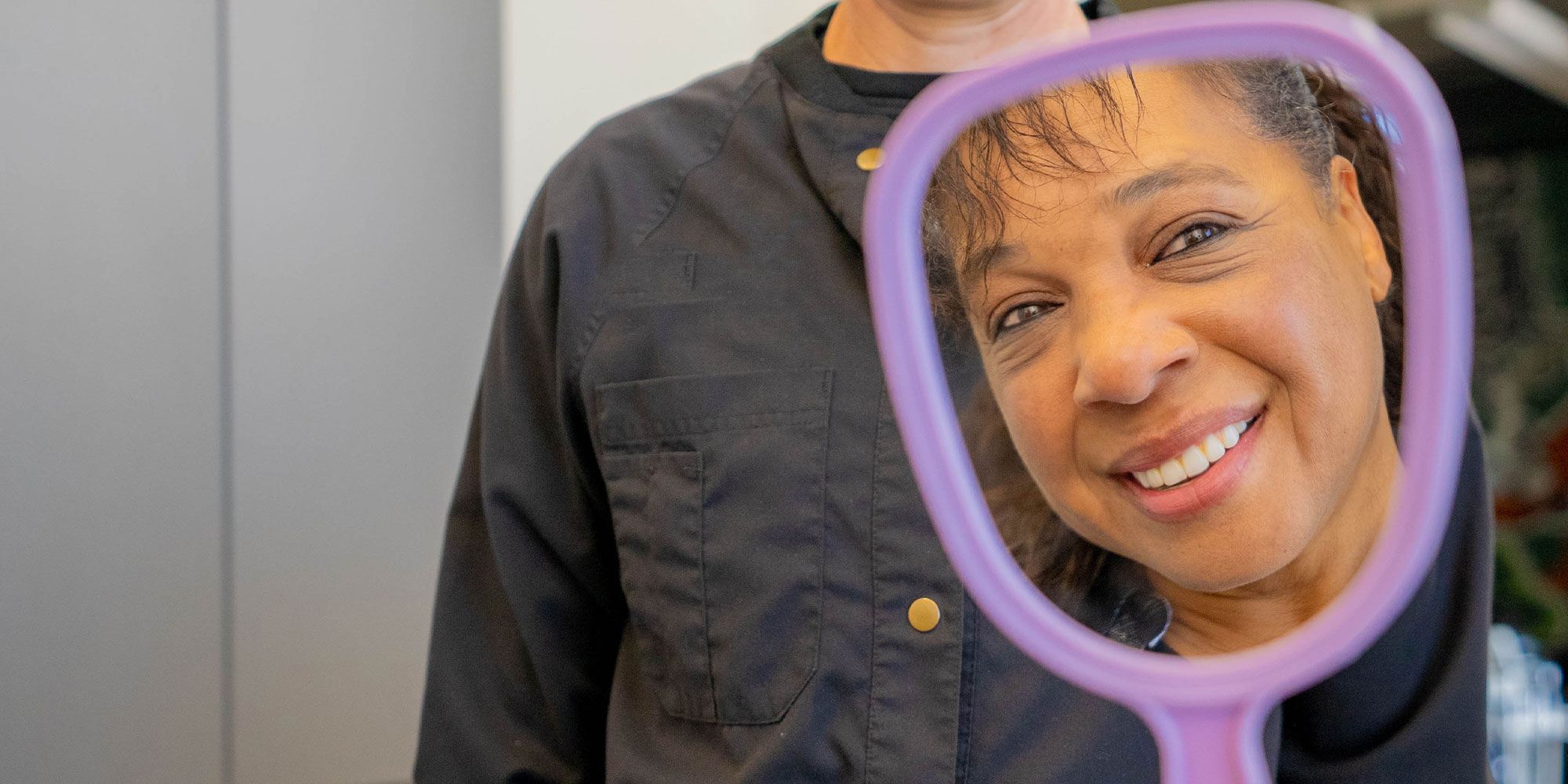 woman smiling into mirror
